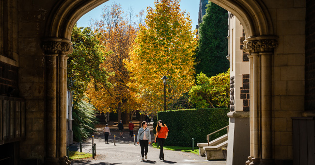 people walking under archway 