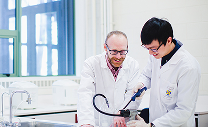 Postgraduate student and supervisor in a lab
