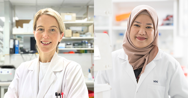 Two women in white lab coats next to equipment 