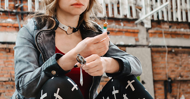 Woman holding syringe and other drug paraphernalia