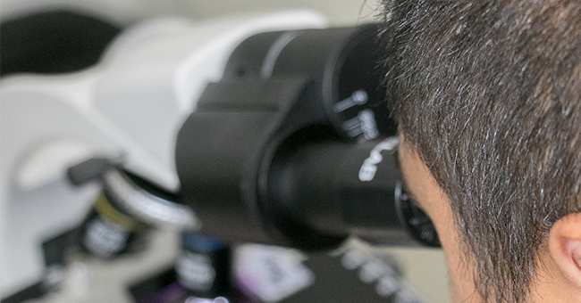 Man looking through microscope